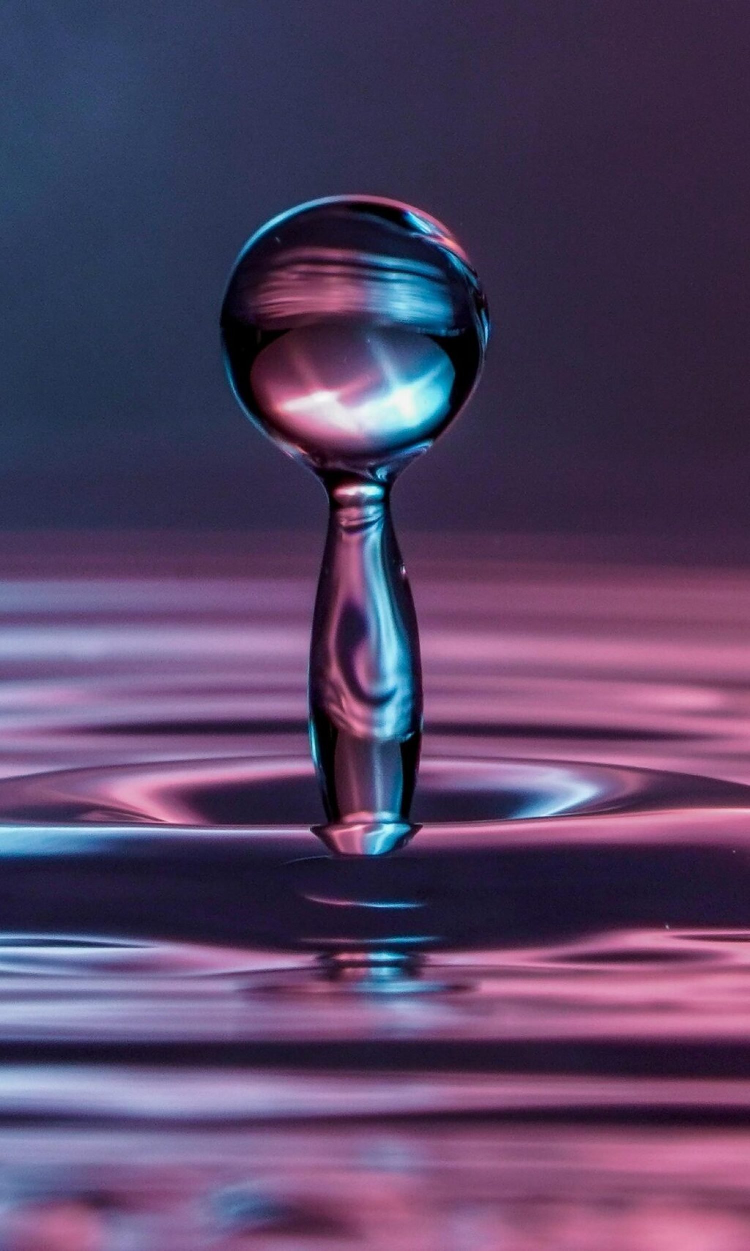 A mesmerizing close-up of a water drop creating ripples, captured with stunning detail.